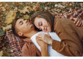 美丽的一对夫妇在秋天的公园里度过时光_924575901