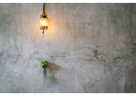 复古灯光装饰水泥墙上有植物_112909101