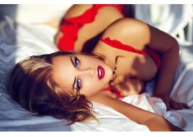 早上年轻的金发女子在床上穿着红色内衣_6933423