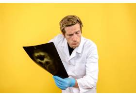前视男医生拿着X光片在黄色办公桌上做内科_11960482