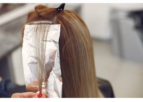 理发师在美发沙龙给她的客户染头发_5912224