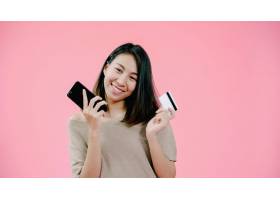 年轻的亚洲女子用智能手机刷卡网购感觉很_4395054