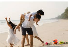 亚洲年轻幸福的一家人晚上在海滩上享受假期_7685875