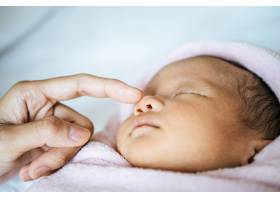 母亲的手摸着新生儿的鼻子_5897177