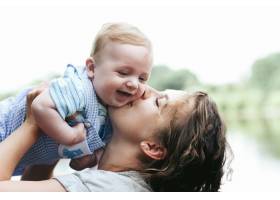 年轻漂亮的妈妈抱着可爱的小男婴微笑_1620603