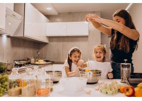 母亲带着两个女儿在厨房烘焙_6213259