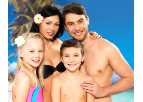 在热带海滩带着两个孩子的幸福微笑的美丽家_11575924
