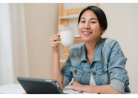 年轻的亚洲女性一边工作一边使用平板电脑_4395104