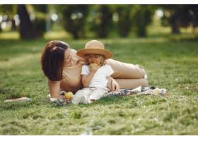 优雅的母亲带着女儿在夏季公园里_9659331
