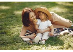 优雅的母亲带着女儿在夏季公园里_9659333