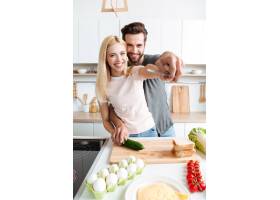 幸福的年轻夫妇在厨房里一起做饭的肖像_8078445