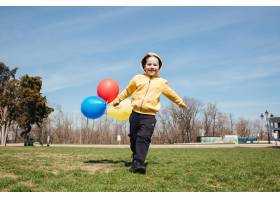 微笑的小男孩在公园里带着气球走在户外_8073991