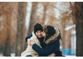 一对年轻可爱的情侣在冬日公园拥抱_9887398