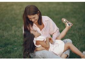 优雅的母亲带着女儿在夏季公园里_9658823