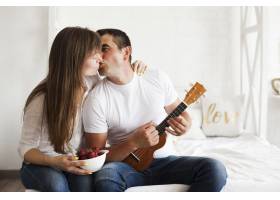 浪漫情侣在卧室边玩四弦琴边接吻_5116575