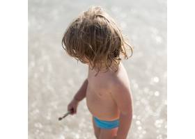 小孩站在海滩上的高角镜头_4937568
