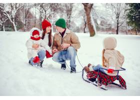 一家人带着可爱的女儿在冬季公园里_4062858