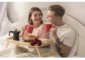 年轻夫妇在床上喝咖啡_3574249