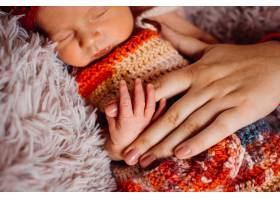 裹着红领巾的新生儿握着母亲的手指_1617091