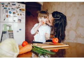 妈妈和女儿在家里的厨房里做蔬菜_2529101