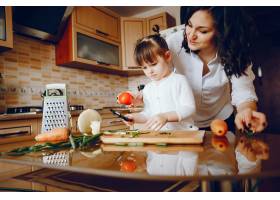 妈妈和女儿在家里的厨房里做蔬菜_2529116