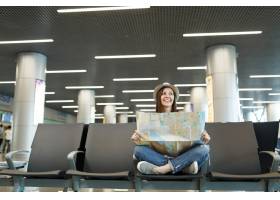 有横渡的腿的年轻微笑的旅客旅游妇女拿着纸_15797503