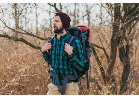 旅行与背包的年轻行家人在秋天森林里戴着格_9654307