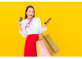 有购物袋和信用卡的画象美丽的年轻亚裔妇女_14890185