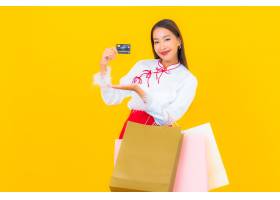 有购物袋和信用卡的画象美丽的年轻亚裔妇女_14890169