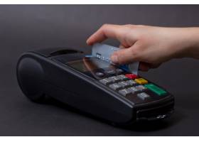 手刷信用卡在商店有信用卡和银行终端的女