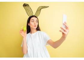 以自拍照作为复活节兔子的白种人妇女在黄