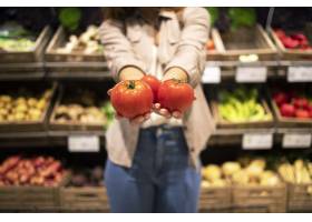 关闭拿着蕃茄菜的手看法在超级市场