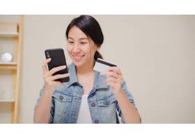使用智能手机的美丽的亚裔妇女购买网上购物