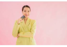 有信用卡的画象美丽的年轻亚裔女商人在颜色_987376301