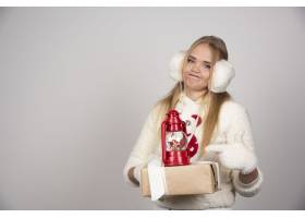 身穿白色套装的年轻女子指着圣诞礼物