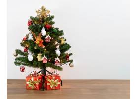 一棵装饰性圣诞树的照片树下有礼物