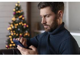 男人在圣诞节检查他的手机