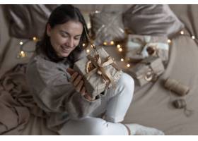 一位女士拿着一个工艺风格的圣诞礼品盒用_19073026