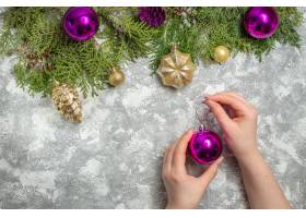 顶视图杉树枝圣诞树装饰品圣诞球在女人手上