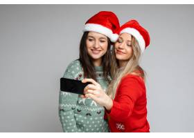 穿着红白相间圣诞帽的漂亮女孩朋友摆出自拍_18688565