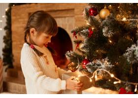 站在圣诞树和礼品盒旁的白人小女孩的肖像